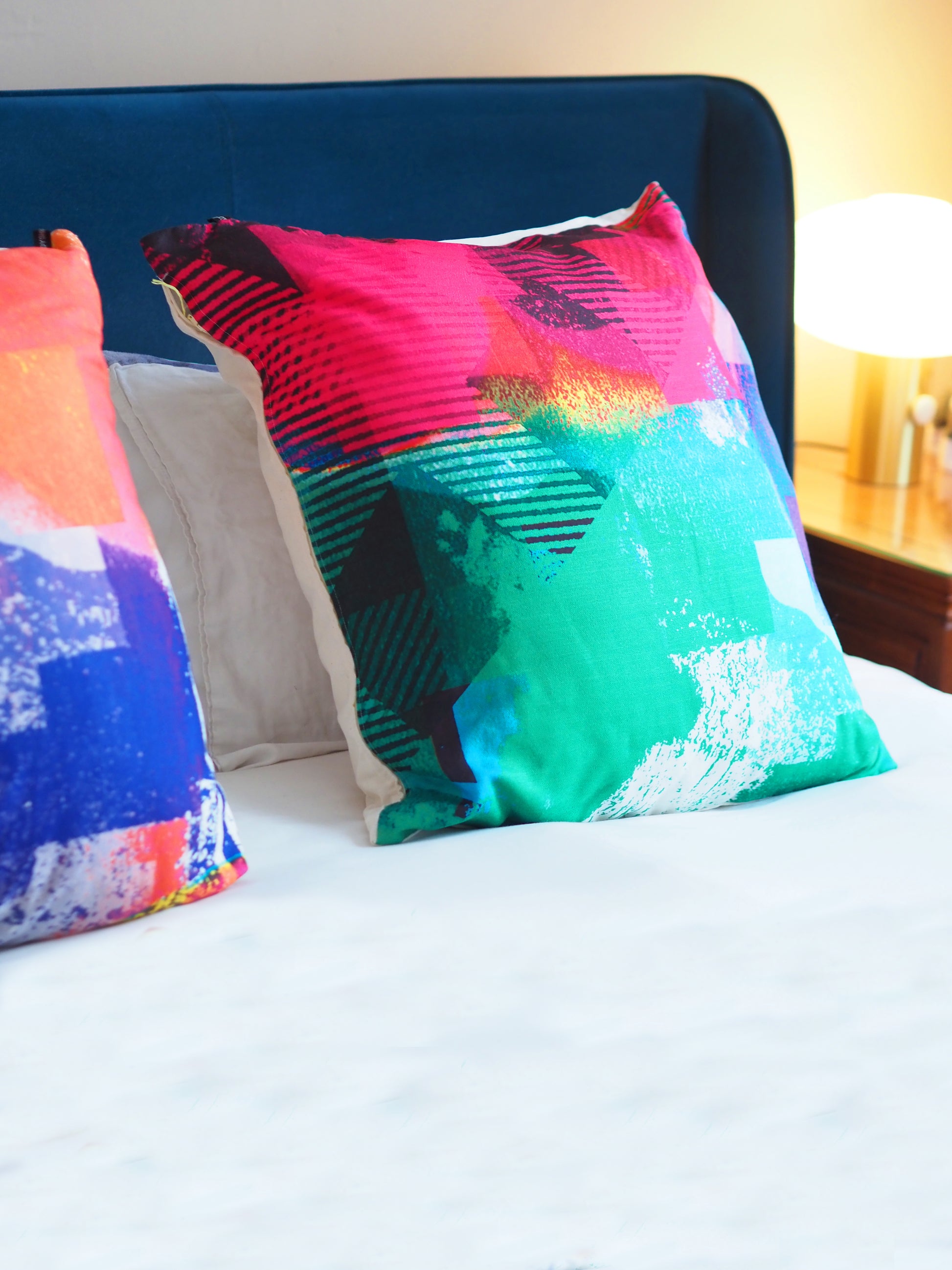 Colorful abstract patterned pillows on a bed