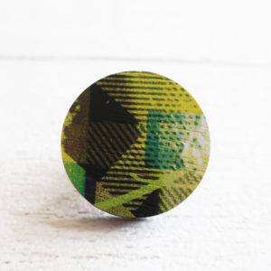 Yellow and black round wooden pin badge